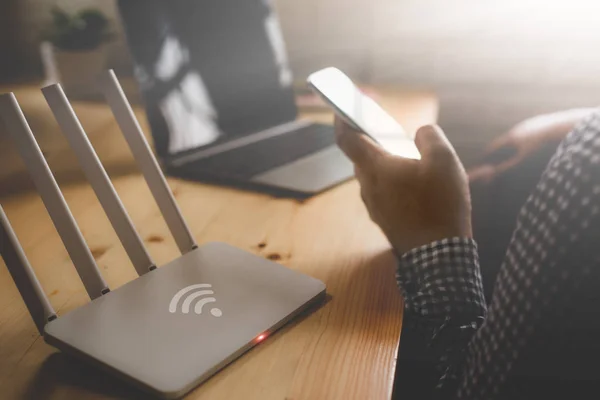 Person using laptop in coffee shop with public Wi-Fi security concerns